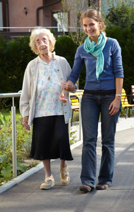 elderly person walking with assistance of companion